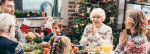A family praying before eating at christmas