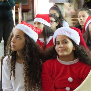 Girls dressed with santa hats in a church