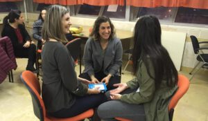 Three women in a circle laughing