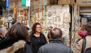 a tour taking place in the city of Jerusalem next to a tourist shop