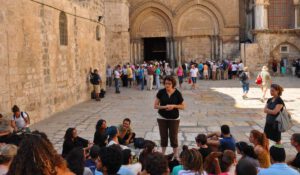 A woman explaining something to a group in front of the church