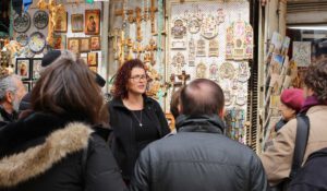 a tour taking place in the city of Jerusalem next to a tourist shop