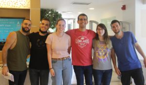 6 students standing next to each other smiling