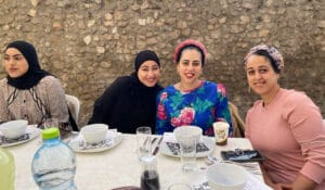 4 women smiling together at iftar dinner