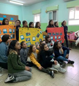 Group of students taking a picture with their work