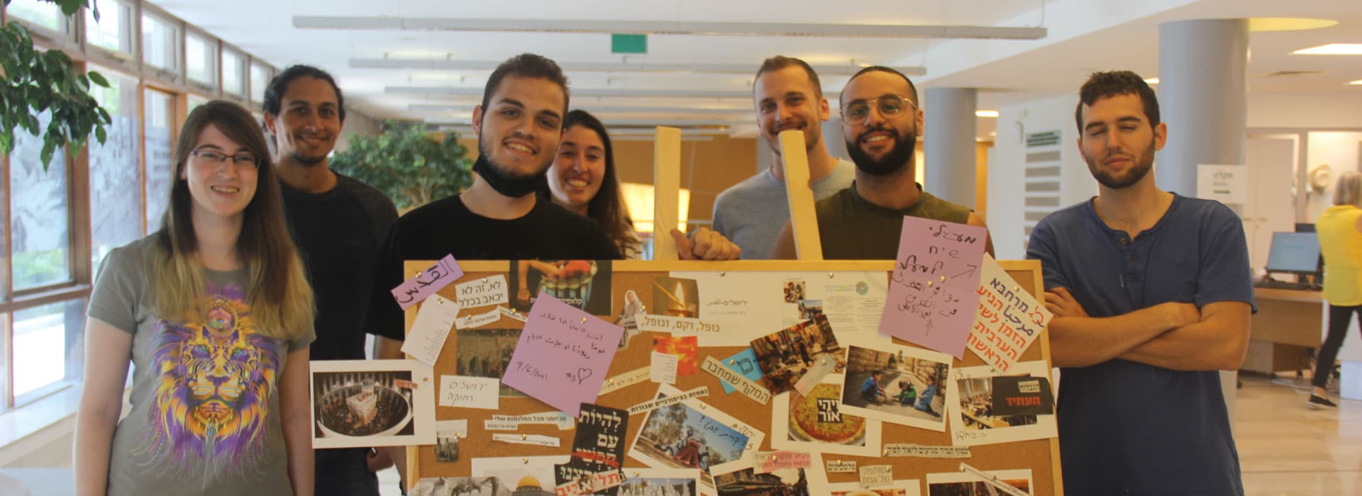 A group of university students showcasing their work on a board