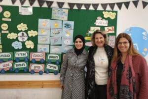 Three teachers taking a picture in a class
